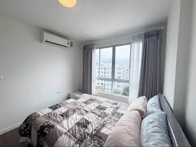 Bright and cozy bedroom with large window and modern air conditioning unit.