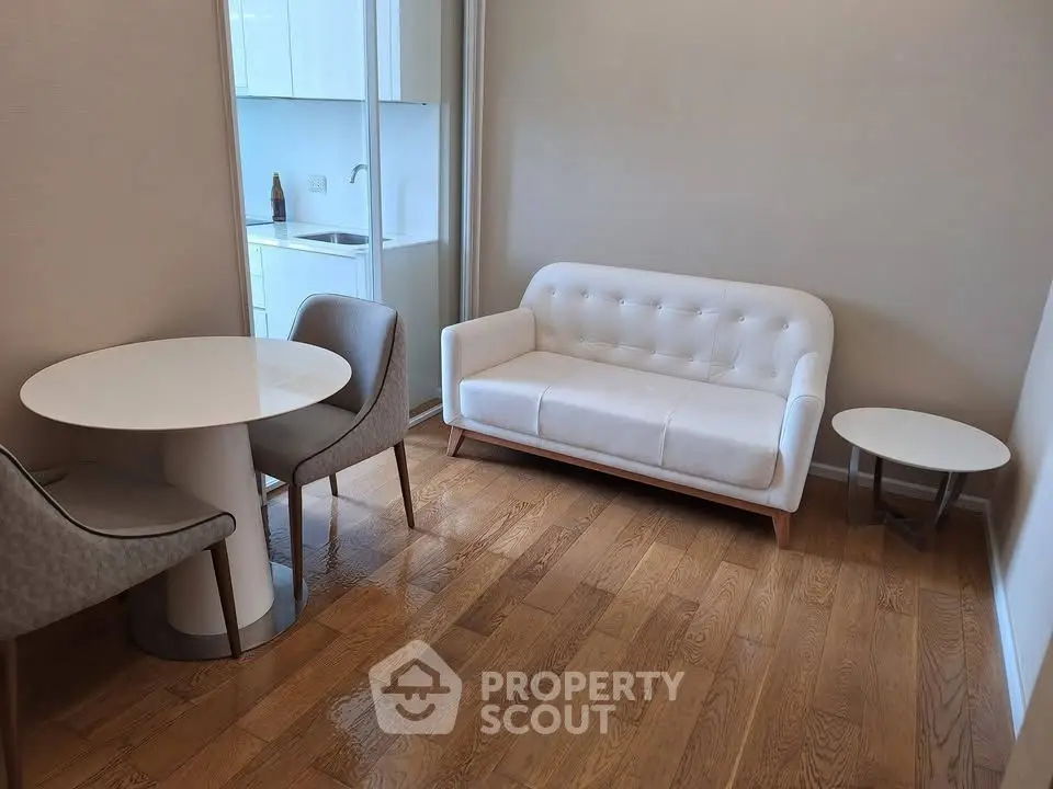 Chic modern living room with elegant white sofa and dining area, featuring sleek wooden flooring and stylish decor.