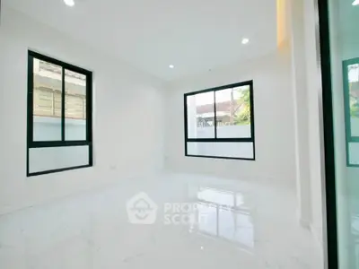 Spacious empty room with large windows and glossy white flooring, perfect for customization.