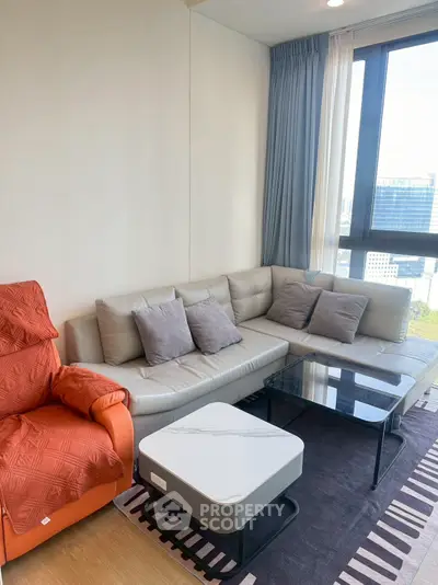 Modern living room with stylish furniture and large window view.