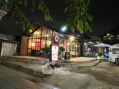 Charming night view of a modern building with inviting outdoor seating area.