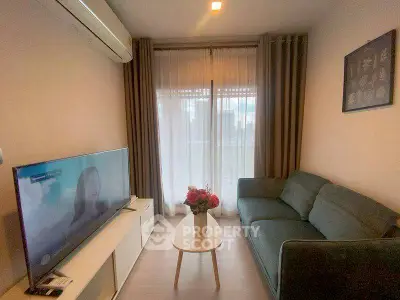 Cozy living room with modern sofa and large TV, perfect for relaxation.