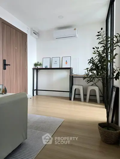 Modern living room with stylish decor and natural light, featuring a sleek air conditioner and minimalist furniture.