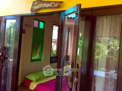 Charming tropical bedroom with vibrant decor and garden view, perfect for a serene retreat.