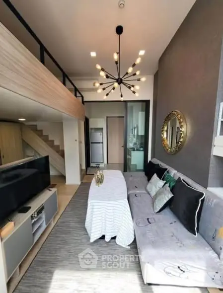 Modern living room with loft design, stylish chandelier, and cozy seating area in a contemporary apartment.