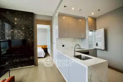 Modern open kitchen with marble countertops and sleek cabinetry in a stylish apartment.
