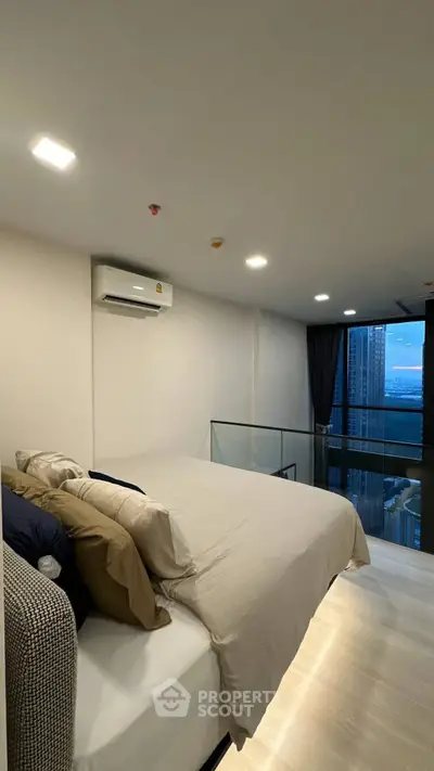 Modern bedroom with city view and cozy bedding in high-rise apartment