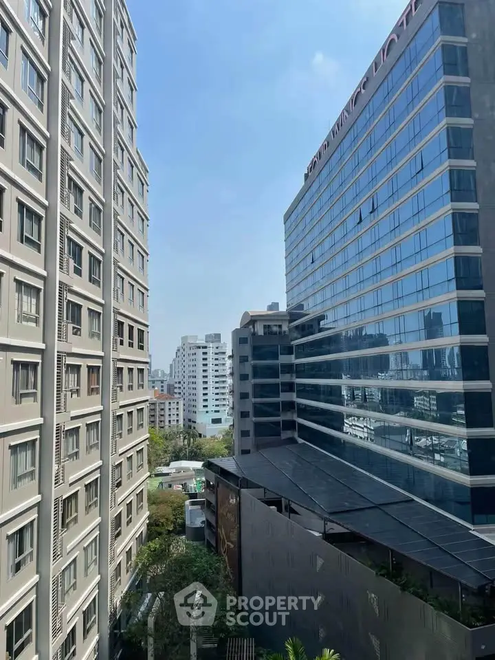 Stunning urban view from high-rise building with modern architecture and clear blue sky.