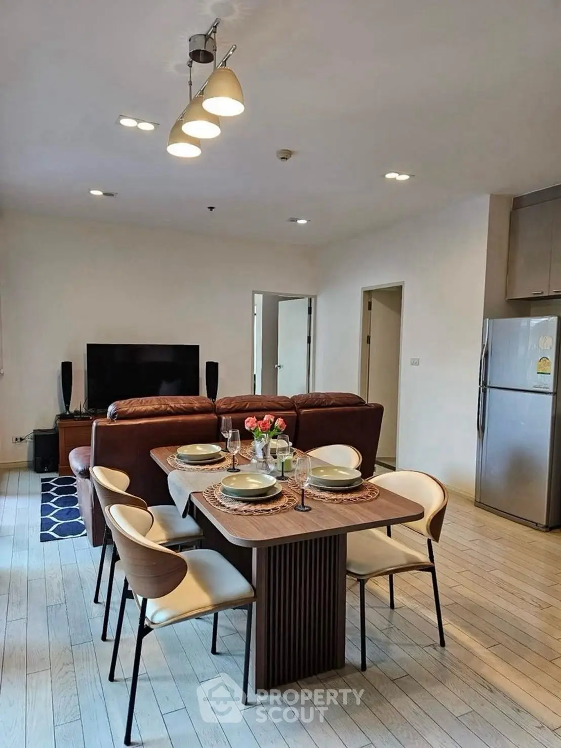Modern living room with dining area and stylish furniture in open layout.