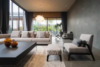 Luxurious modern living room with elegant furniture and large windows offering garden view.