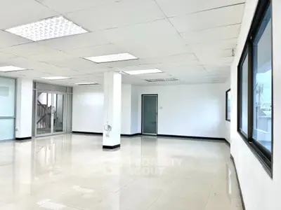 Spacious modern office space with large windows and bright lighting
