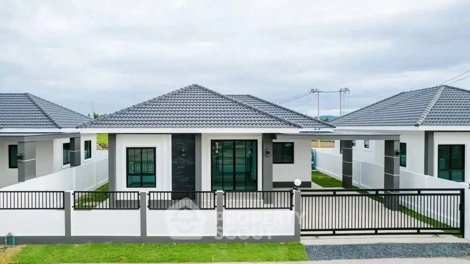 Modern single-story house with sleek design and spacious front yard.