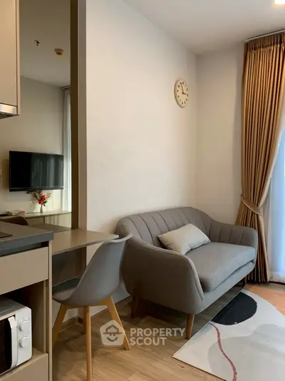 Cozy living room with modern sofa, wall clock, and TV, perfect for relaxation.