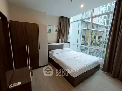 Modern bedroom with large window and stylish furniture in urban apartment