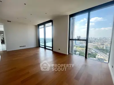 Spacious modern living room with stunning city view and floor-to-ceiling windows.