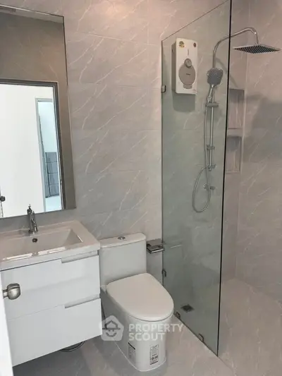 Modern bathroom with sleek shower and stylish vanity in contemporary apartment.