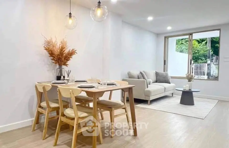 Modern living room with dining area, stylish decor, and natural light.
