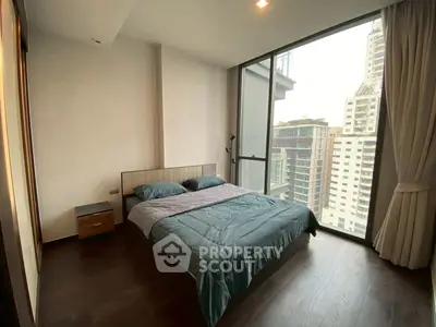 Modern bedroom with large window offering city view in high-rise apartment