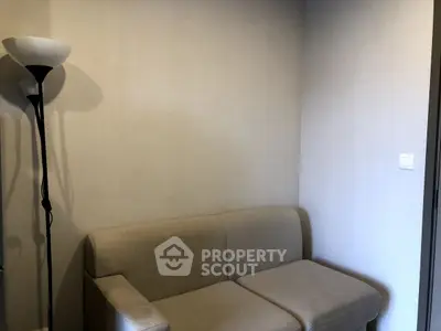 Cozy living room corner with beige sofa and modern floor lamp