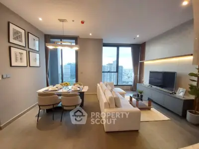 Modern living room with dining area and city view, featuring sleek furniture and elegant decor.