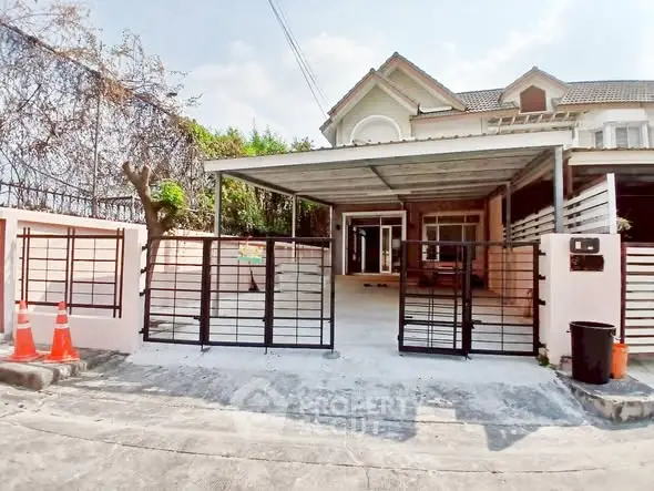 Charming suburban house with gated driveway and covered carport, perfect for family living.