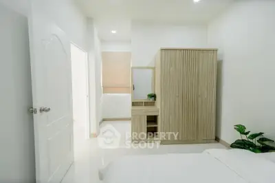 Modern minimalist bedroom with sleek wardrobe and bright lighting