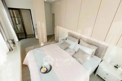 Luxurious bedroom with elegant decor and natural light, featuring a cozy bed and stylish furnishings.