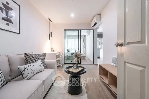 Modern living room with stylish decor and open layout, featuring a cozy sofa and sleek furniture.