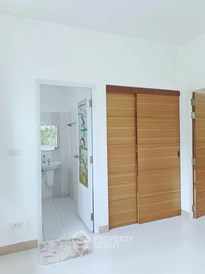 Bright interior with sliding wooden doors and glimpse of modern bathroom