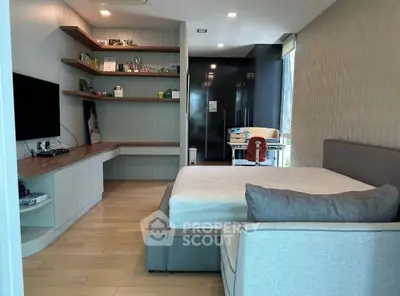 Modern bedroom with sleek design, featuring a cozy bed, built-in shelves, and a large TV for ultimate comfort.