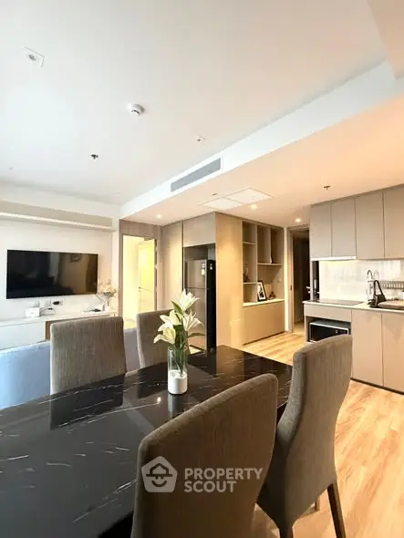 Modern open-plan living room and kitchen with elegant dining area and sleek appliances.