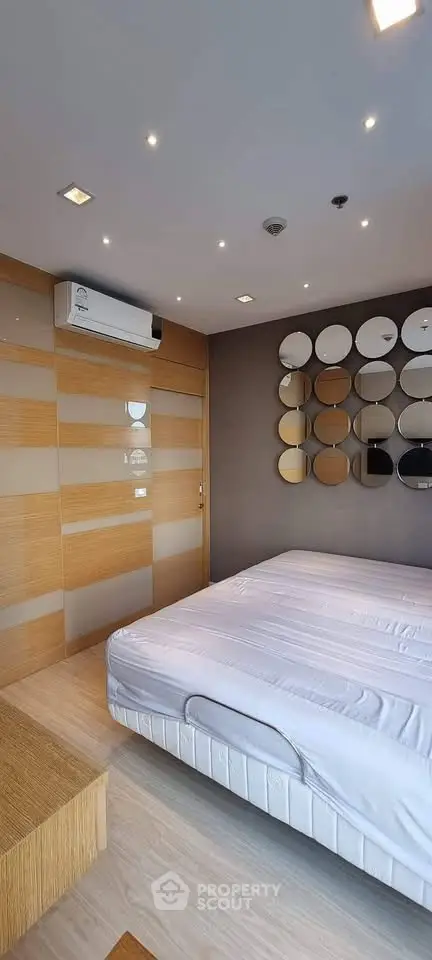 Modern bedroom with stylish decor and air conditioning in a contemporary apartment.
