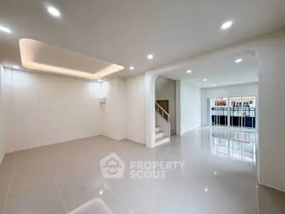 Spacious modern living room with glossy tiled floors and recessed lighting