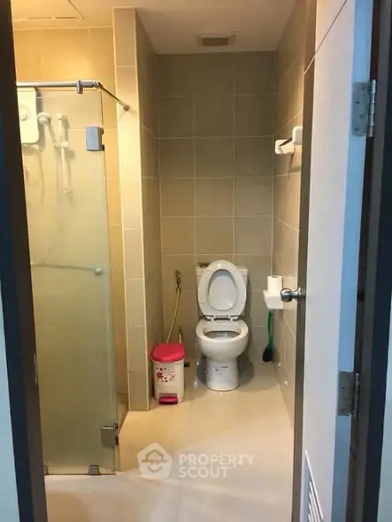 Modern bathroom with glass shower and tiled walls in a real estate property.