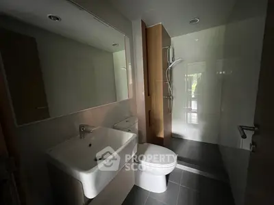 Modern bathroom with sleek fixtures and walk-in shower in contemporary home.
