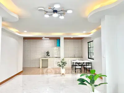 Spacious modern living room with open kitchen and stylish lighting, perfect for contemporary living.