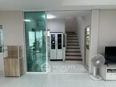 Modern interior with glass partition, sleek staircase, and minimalist decor