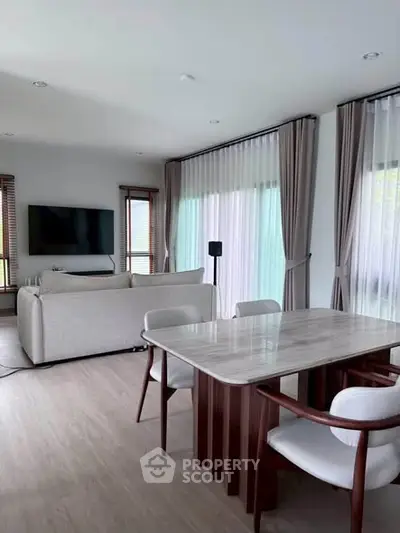Spacious modern living room with elegant dining area and large windows