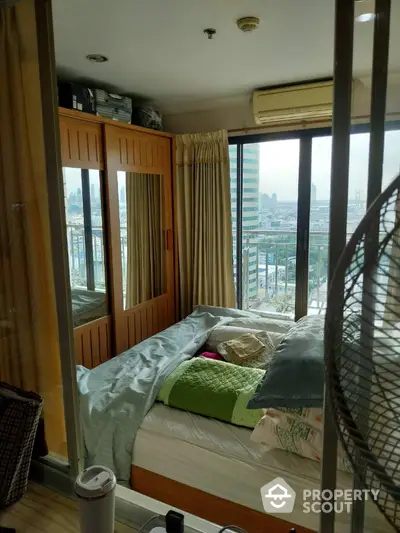 Cozy bedroom with city view and mirrored wardrobe in modern apartment