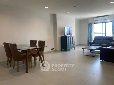 Spacious living room with modern furniture and natural light, ideal for comfortable living.