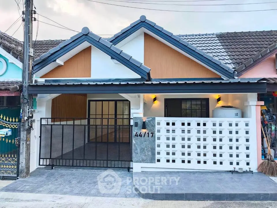 Charming single-story home with modern facade and gated entrance in a cozy neighborhood.