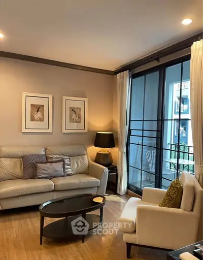 Elegant living room with cozy seating and large window overlooking balcony