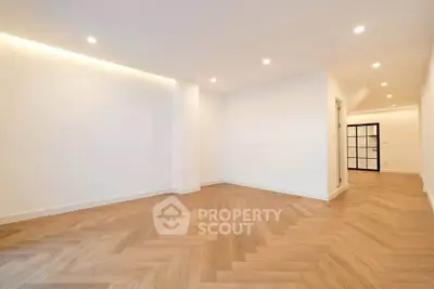 Spacious modern living room with elegant wooden flooring and recessed lighting