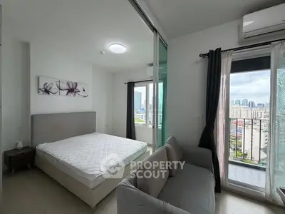 Modern bedroom with balcony and city view, featuring a cozy bed and stylish decor.