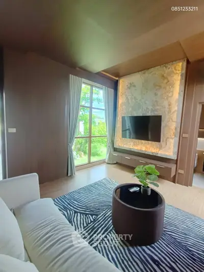 Luxurious living room with modern decor, large window, and stylish TV wall feature.