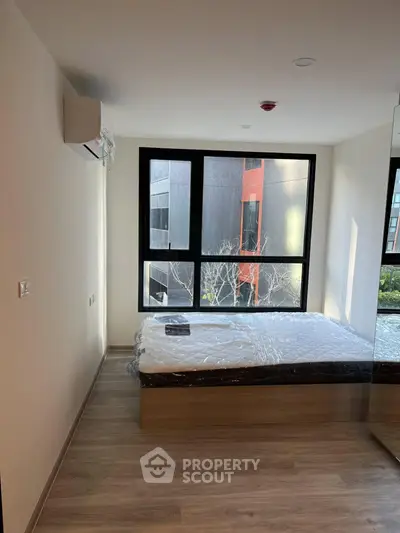 Modern bedroom with large window and natural light in contemporary apartment