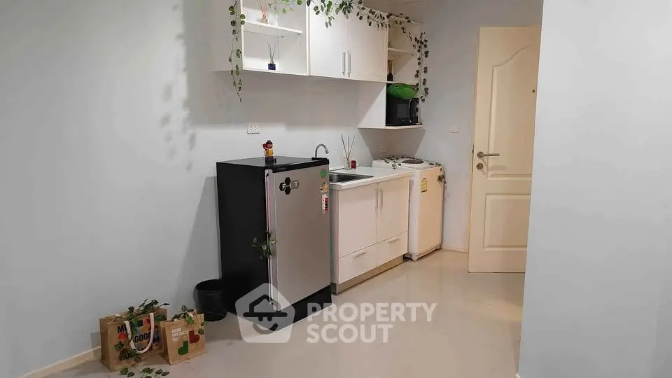 Charming compact kitchen with modern appliances and sleek cabinetry, perfect for efficient living.