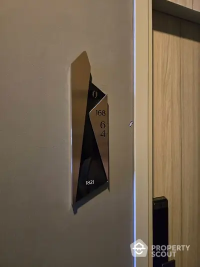 Modern apartment door with sleek metallic room number plaque