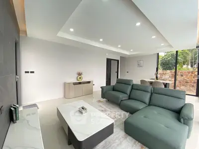 Modern living room with sleek furniture and large windows offering natural light