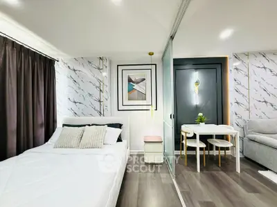 Modern studio apartment with stylish decor, featuring a cozy bed, elegant dining area, and chic wall art.